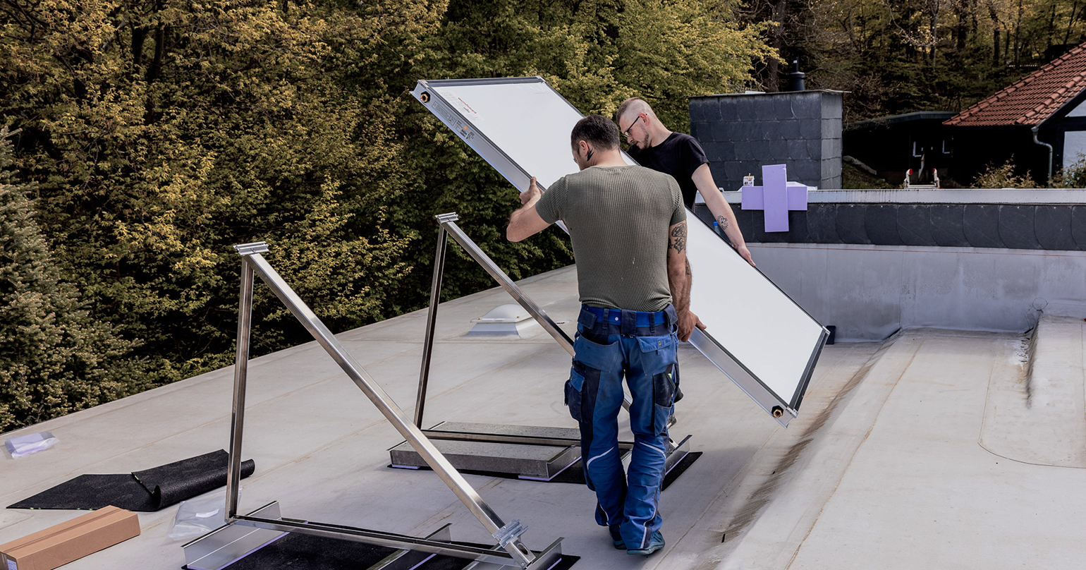 Zwei Heizungstechniker montieren eine Solaranlage