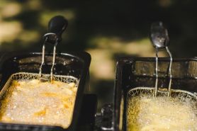 Zwei Friteusen mit Pommes und öl in Betrieb