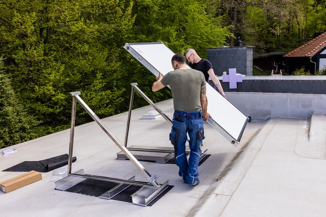 Zwei Heizungstechniker bei der Installation von Solarkollektoren